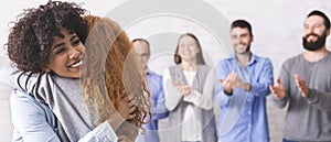 Cheerful people hugging during group therapy session