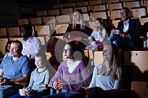 Cheerful people watching comedy in movie theater