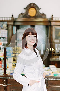 Cheerful pharmacist chemist woman standing in pharmacy drugstore