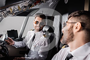 cheerful pilots in sunglasses looking at