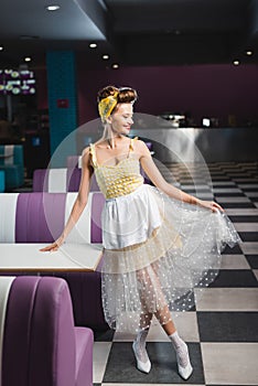 cheerful pin up waitress holding skirt