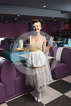 cheerful pin up waitress holding tray