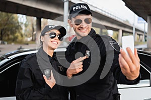 Cheerful police officers showing badge and