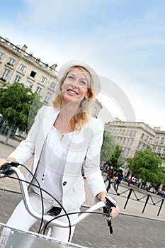 Cheerful portrait of middle-aged woman on city bike