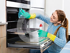 Cheerful positive adult girl removing snuff in oven