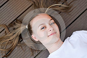 Cheerful positive pretty kid, teen age girl, being in great mood and showing her smile and long hair tails