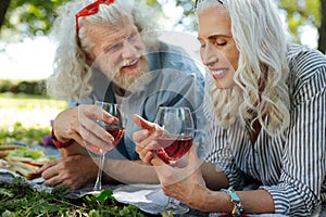 Cheerful positive woman looking at the glass with wine