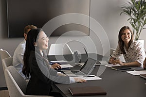 Cheerful positive young Asian business professional laughing on corporate meeting