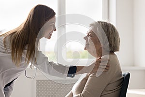 Cheerful practitioner woman visiting senior 80s female patient