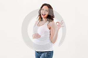 Cheerful pregnant woman showing okay gesture.