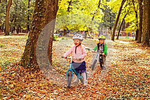 Cheerful preschool kids outdoors on balance bikes