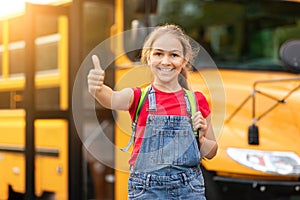 Cheerful Preteen Boy Standing Near Yellow School Bus And Showing Thumb Up