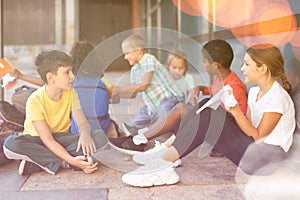 Cheerful preteens resting outdoors in schoolyard during break