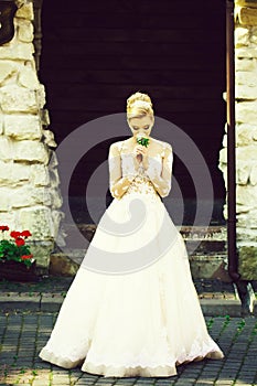 Cheerful girl or bride in white wedding dress with flower