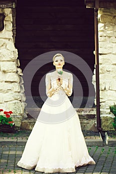 Cheerful girl or bride in white wedding dress with flower