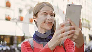 Cheerful pretty girl making selfie photo on ubran street on vacation trip in Paris. Smiling having fun