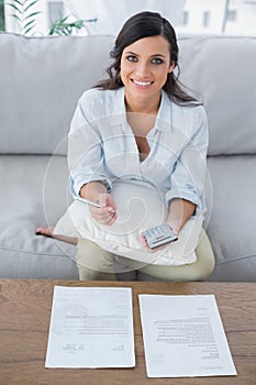 Cheerful pretty woman doing her accounts