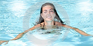 Pretty young girl swimming in the pool