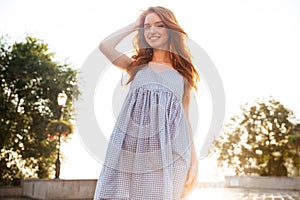 Cheerful pretty young redhead girl with long hair posing