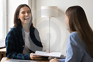 Cheerful project manager talking to business colleague in casual clothes