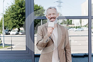 cheerful reporter in blazer holding microphone