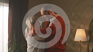 Cheerful retired couple dancing at home