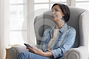Cheerful retired mature woman using online service, application