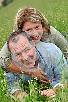 Cheerful retired people relaxing in grass