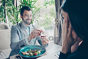 Cheerful romantic brunet bearded guy is proposing to his amazed