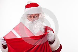 Cheerful Santa Claus is carrying a bag of presents