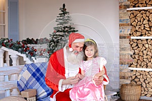 Cheerful Santa Claus talking to little girl.