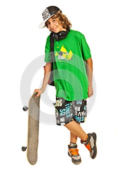 Cheerful schoolboy teen with skateboard