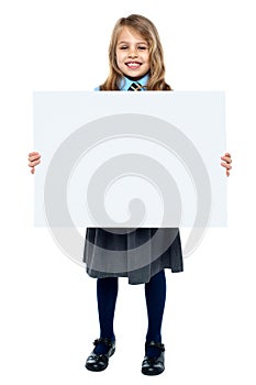 Cheerful schoolkid showcasing blank whiteboard