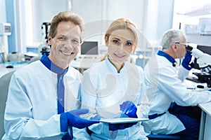 Cheerful scientists holding a tablet in the lab