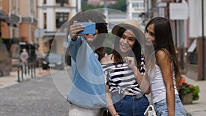 Cheerful selfie diverse girls posing on city street