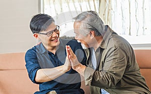 Cheerful senior asian father and middle aged son in living room, Happiness Asian family concepts