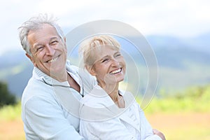 Cheerful senior couple enjoying outdoors laughing