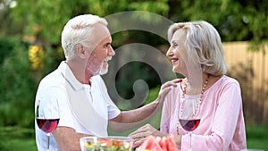 Cheerful senior couple having romantic date in backyard, meeting website