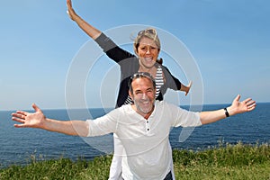 Cheerful senior couple standing by the seaside
