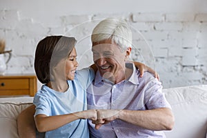 Cheerful senior granddad and grandson giving friendly fist bump