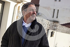 Cheerful senior man in front of house