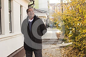 Cheerful senior man in front of house