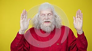 Cheerful senior man opening face closed with hands and laughing. Portrait of joyful Caucasian male retiree having fun on