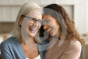 Cheerful senior mom and daughter woman hugging with heads touch