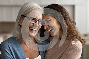 Cheerful senior mom and daughter woman hugging with heads touch