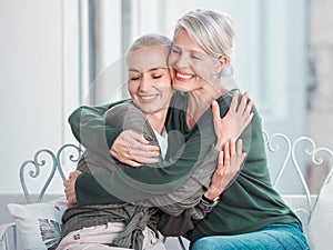 Cheerful senior mother hugging grownup daughter. Loving caucasian mom hugging her daughter while sitting together at