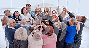 Cheerful senior people exercising with arms raised at retirement