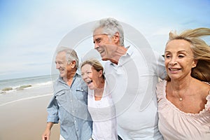 Cheerful senior people walking on the beach