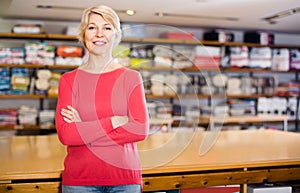 Cheerful senior seller showing wide assortment of home textiles