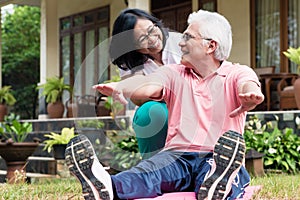 Cheerful senior woman helping her partner during workout session